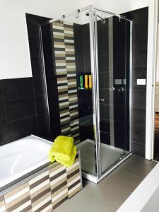 La salle de bains est pourvue d'une douche et d'une baignoire avec une serviette jaune. dans l'établissement Gone skiing, à Bonnie Doon