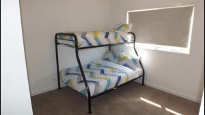 Ce lit superposé se trouve dans un dortoir doté d'une fenêtre. dans l'établissement Gone skiing, à Bonnie Doon