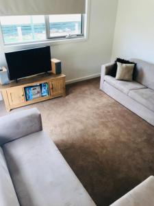 a living room with two couches and a flat screen tv at Gone skiing in Bonnie Doon