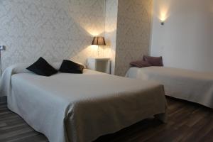 
a hotel room with two beds and two lamps at Hotel Au Chapon Fin in Poitiers
