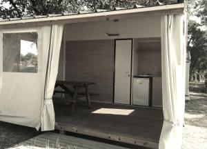 a screened in porch of a cabin with a picnic table at Camping Mussonville in Soulac-sur-Mer