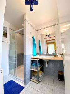 ein Bad mit einer Dusche und einem Waschbecken in der Unterkunft Jolie maison récente confort Proche des plages in Riantec