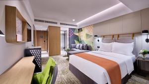 una camera d'albergo con un grande letto e un divano di Holiday Inn Guangzhou South Lake, an IHG Hotel-Free shuttle bus to Canton Fair Complex during Canton Fair Period a Canton