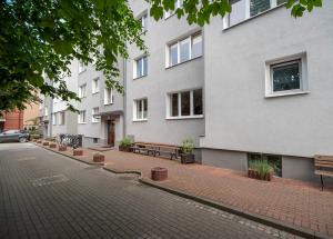 ceglana ulica z ławkami przed budynkiem w obiekcie Mieszkanie Next - ACCO RENT w mieście Sopot