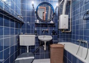 a blue tiled bathroom with a toilet and a sink at Mieszkanie Next - NoclegiSopot in Sopot