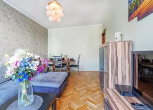 salon z kanapą i wazą kwiatów w obiekcie Mieszkanie Next - ACCO RENT w mieście Sopot