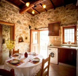 cocina con mesa y mantel blanco en Luxurious Stone Apartment 1, en Rókka