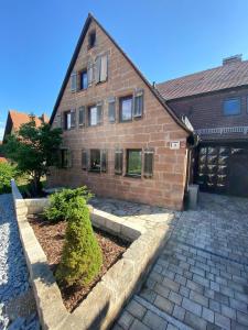 a brick house with a courtyard in front of it at Ferienwohnung Hopfengarten in Spalt