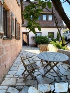 a picnic table and chairs on a stone patio at Ferienwohnung Hopfengarten in Spalt