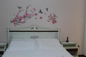 ein Schlafzimmer mit einem Bett mit Vögeln und Blumen an der Wand in der Unterkunft La casa sulla dolina in Campoli Appennino