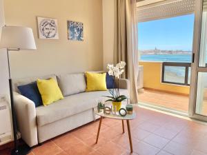 a living room with a couch and a view of the ocean at Appartamenti Sole 1 in Alghero