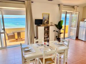 a dining room with a table and a view of the ocean at Appartamenti Sole 1 in Alghero