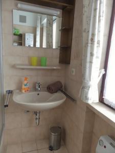 La salle de bains est pourvue d'un lavabo et d'un miroir. dans l'établissement Ferienwohnung Nordenau, à Schmallenberg