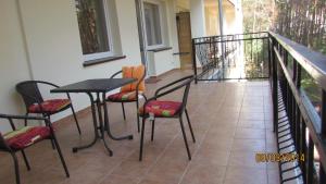 a balcony with a table and chairs on a porch at jaren in Łukęcin