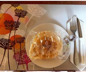 a white plate with a donut on a table at Luxurious Stone Apartment 1 in Rókka