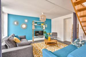 ein Wohnzimmer mit einer Wand mit blauen Akzenten in der Unterkunft Appart' Grand'Place in Lille