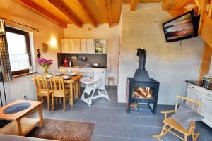 a living room with a fireplace and a table and chairs at Domki Gościniec Bobolin in Bobolin