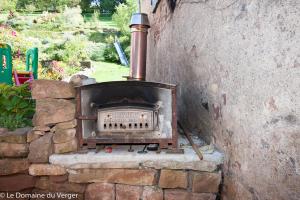 een bakstenen oven zittend in een stenen muur bij Le Domaine du Verger gîtes et SPA in Osenbach