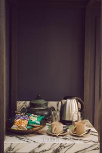 a table with a tea pot and a plate of food at iuDia Hotel in Phra Nakhon Si Ayutthaya