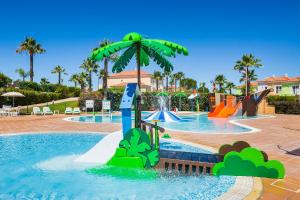 a swimming pool with a blue and green fountain at Eden Resort in Albufeira