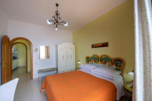 a bedroom with a bed with an orange bedspread at Il Giardino Dei Limoni in Praiano