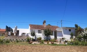 una casa blanca con algunas plantas en el patio en Casa da Quinta, en Sao Pedro de Tomar