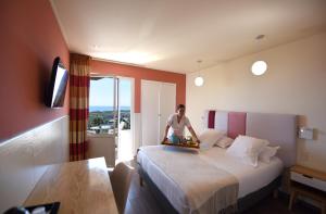 a man sitting on a bed in a hotel room at Ostella Spa & Resort in Bastia