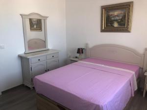 een slaapkamer met een paars bed en een spiegel bij Guadalajara apartamento in Torrevieja