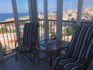 two chairs and a table in a room with a view at Guadalajara apartamento in Torrevieja