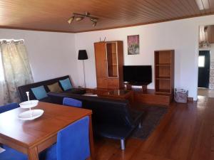 uma sala de estar com um sofá e uma mesa em Casa da Quinta em Sao Pedro de Tomar