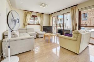 a living room with white furniture and a fan at Seafront Protaras Villas in Protaras