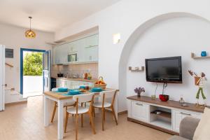 a kitchen and dining room with a table and a tv at Oneiric Harmony in Mikri Vigla