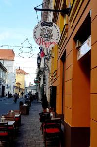 a street with tables and chairs outside of a restaurant at Malasits Apartman in Győr