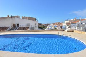 a large blue swimming pool in front of a building at Penthouse with Panoramic View by NRAS in Santa Pola