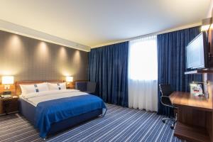 a hotel room with a bed and a flat screen tv at Holiday Inn Express Neunkirchen, an IHG Hotel in Neunkirchen