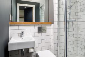 a white bathroom with a sink and a mirror at ibis Budget Sheffield Centre St Marys Gate in Sheffield +78 photos