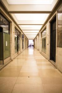 un pasillo vacío en un edificio con gente caminando por él en The Gallery Boutique Rooms en Trieste