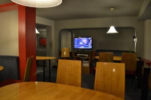 a restaurant with tables and chairs and a television at Hotel Amalfi in Asuncion