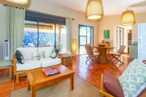 Una sala de estar con un sofá blanco y una mesa. en Corail - Villa de charme pieds dans l'eau à Saint-Gilles-les-Bains, en Saint-Gilles-les-Bains
