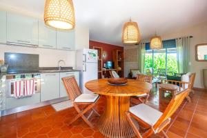 cocina y comedor con mesa de madera y sillas en Corail - Villa de charme pieds dans l'eau à Saint-Gilles-les-Bains, en Saint-Gilles-les-Bains