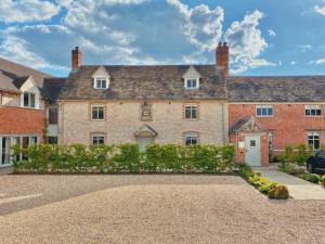 an exterior view of a large brick house with a driveway at The Harcourt Arms in Witney
