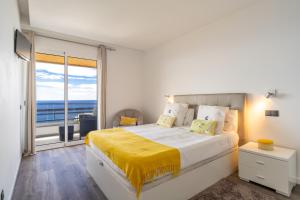 een slaapkamer met een groot bed en een groot raam bij Monumental Apartment in Funchal