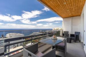 een balkon met een tafel en stoelen en de oceaan bij Monumental Apartment in Funchal