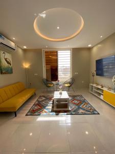 sala de estar con sofá amarillo y mesa en A - 369 مقابل الراشد مول, en Abha