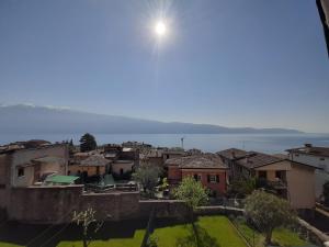 Blick auf eine Stadt mit der Sonne am Himmel in der Unterkunft La Petite Maison in Gargnano