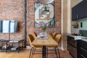 comedor con pared de ladrillo, mesa y sillas en Boutik Boheme Le Loft Batignolles, en París 9 fotos más