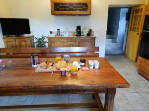 una mesa de madera con comida y bebidas. en L'Arbonnaise en Arbon