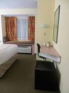 una camera d'albergo con scrivania, letto e finestra di Cedar Bluff Inn a Knoxville