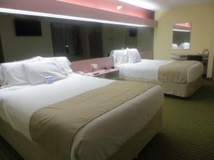 Cette chambre d'hôtel comprend 2 lits avec des draps blancs. dans l'établissement Cedar Bluff Inn, à Knoxville