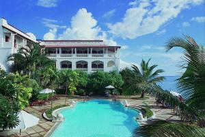 a resort with a swimming pool in front of a building at Zanzibar Serena Hotel in Zanzibar City